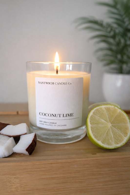 Coconut Lime Scented Soy Wax candle with a glowing flame, to remind you of your favourite tropical location