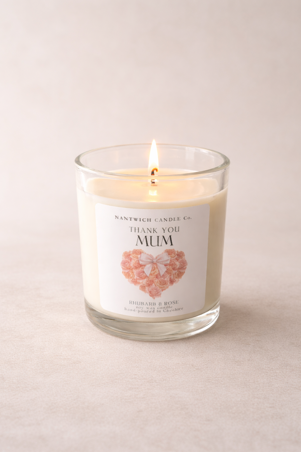 Mothers Day Rhubarb & Rose Scented Soy Wax Candle with 'Thank You Mum' label, lit and fragrant.